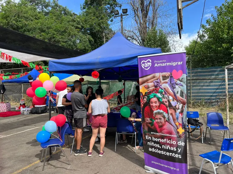 Feria benéfica Proyecto Amarmigrar con personas y globos.