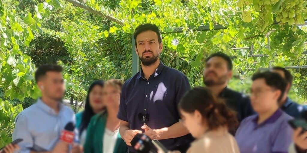 Hombre hablando durante rueda de prensa al aire libre.