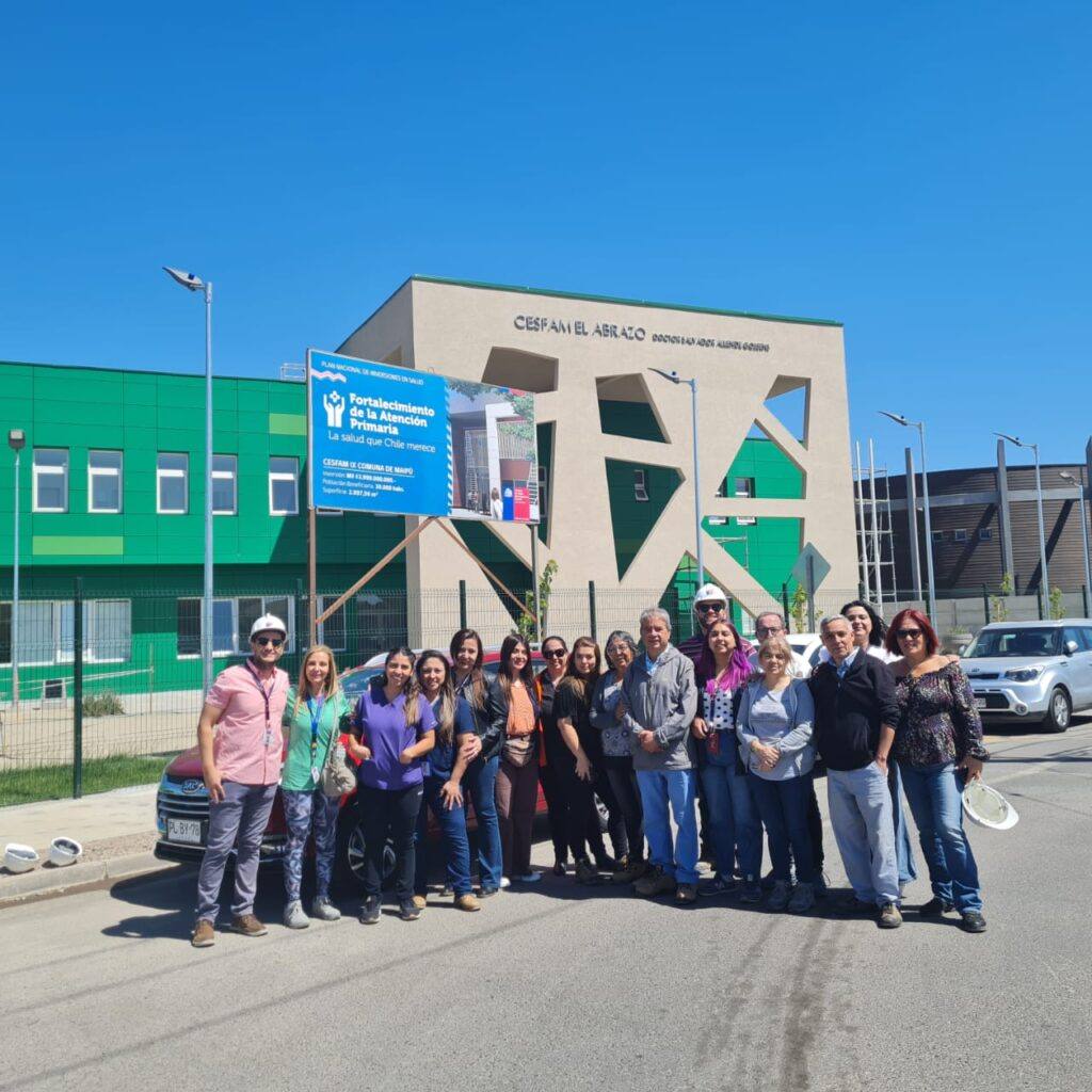 Grupo de personas frente a edificio de salud.