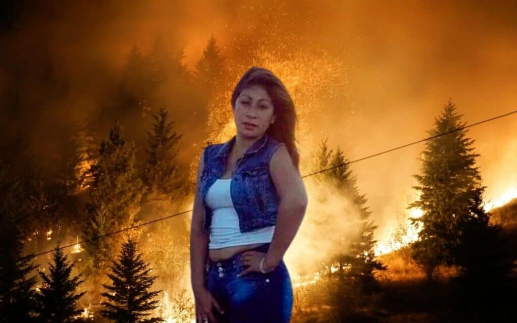 Mujer delante de incendio forestal nocturno.