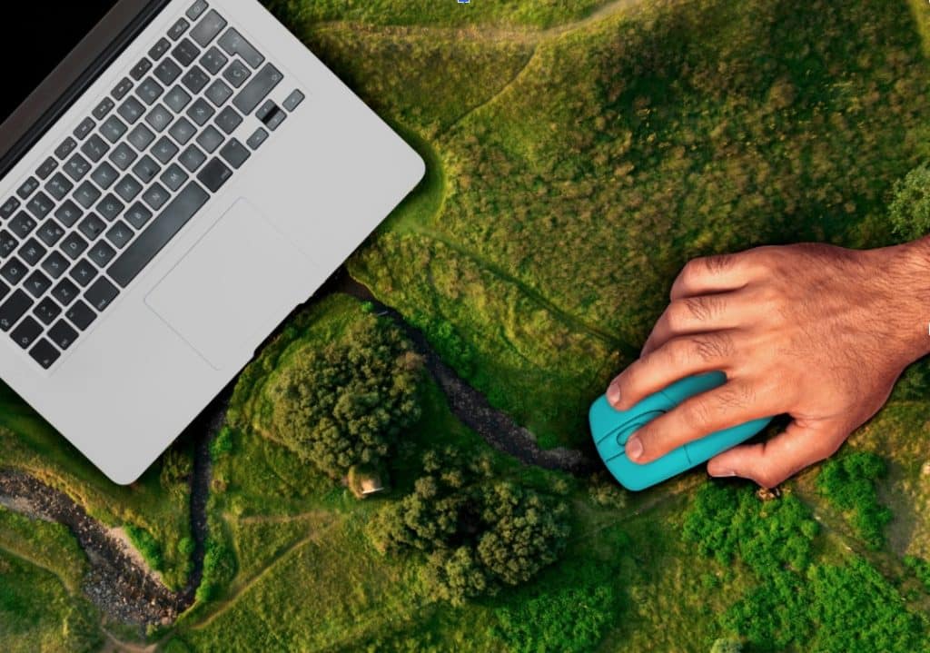 Mano usando mouse sobre paisaje