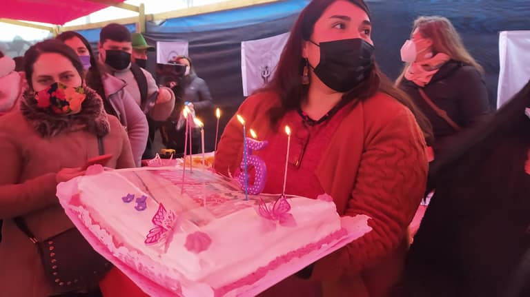 Natalie Arriagada sostiene torta de celebración por los 5 años de Vivienda Digna.