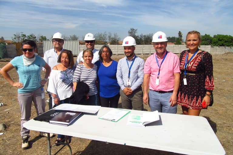 Equipo de ingenieros con cascos en sitio de construcción.