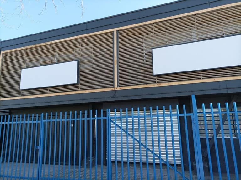 Fachada con vallas y carteles en blanco.