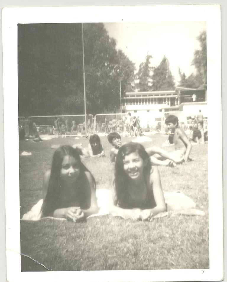 Dos chicas sonriendo en parque soleado, foto antigua.