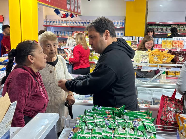 Cristián Alvo, Gerente de la Cadena de Supermercados habla con una clienta en la inauguración del supermercado