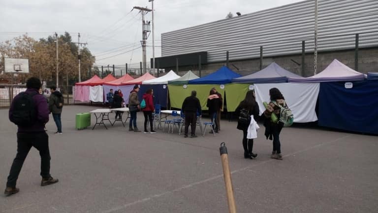 Feria al aire libre con carpas y gente.
