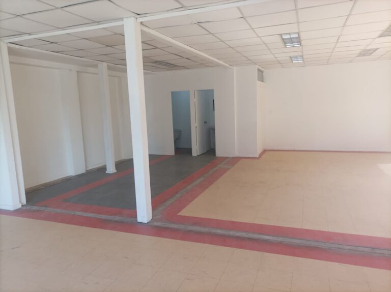 Oficina vacía con columnas y suelo de baldosas.