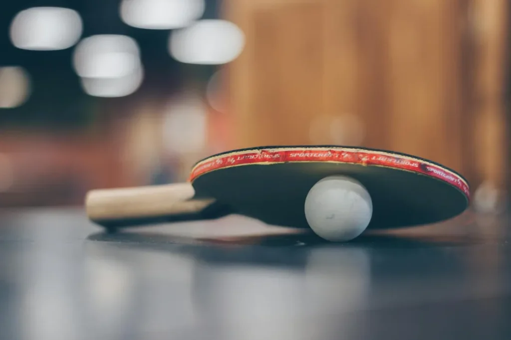Paleta y pelota de tenis de mesa.