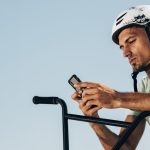 Sigue las competiciones de ciclismo con total confianza en línea 1 bmx rider looking his phone medium shot Grande